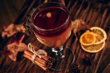 mulled red wine with spices and fruits on a wooden rustic table. Traditional hot drink at Christmas time