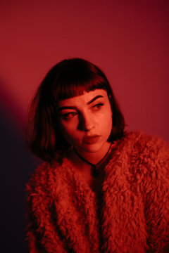 Stylish woman in red lights of studio