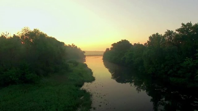 aerial view of river at sunrise 4K, fly over morning mist on the river, Very high view of the river at sunrise, Aerial view of mystical river at sunrise with fog, sun above the river aerial