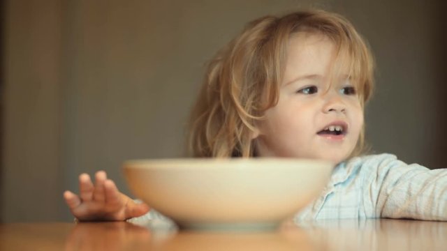 No food. Cute child has no appetite. Kid Boy In Front of a Meal No Appetite does not want to eat healthy homemade food. Boy with unhappy face between mother want to having food for lunch, picky eater 