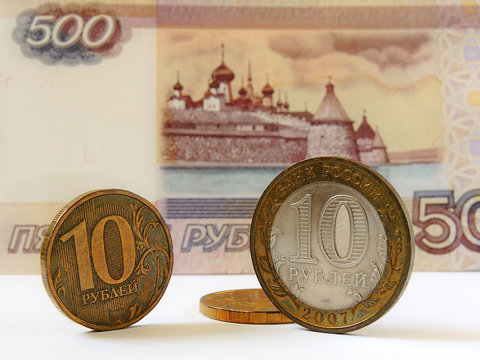 Russian coins 10 rubles are in front of the banknote 500 rubles. The banknote depicts the Solovetsky monastery. Close-up