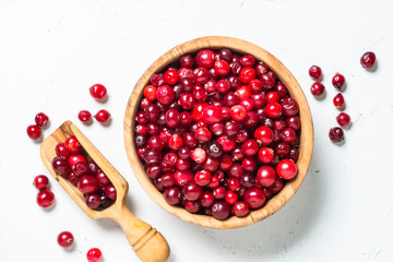 Cranberry in wooden bowl on white background.