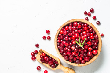 Cranberry in wooden bowl on white background.