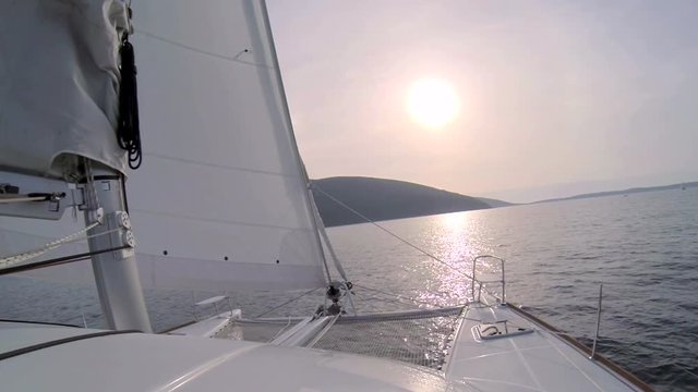 Catamaran boat sails the sea on the sunset