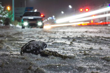 lost car keys on the road powdered with the first snow at night. on blurred background