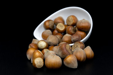 Tasty hazelnuts on a black kitchen table. Ingredients for preparing the dough in the home kitchen.