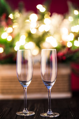 New year holiday or christmas green background. Branches of christmas trees decorated with golden lights, garlands, toys and empty champagne glasses. Night illumination. New Year greeting concept
