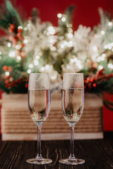 Christmas composition christmas trees decorated with golden lights, garlands, toys and empty champagne glasses.