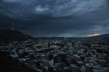 Fototapeta na wymiar Tbilisi. View of the city and a monument to the mother of Georgia from the hill during the storm.