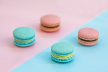 Fototapeta na wymiar Colorful french macarons on pink and blue background. Top view. Pastel colors.Concepts about decoration, food background. flat lay