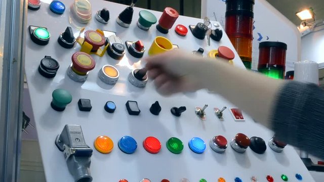 Person clicks pushing on the control panel buttons and pressing the lever close-up. Person tilts the lever to turn it on oa turn off. Control buttons panel close-up.