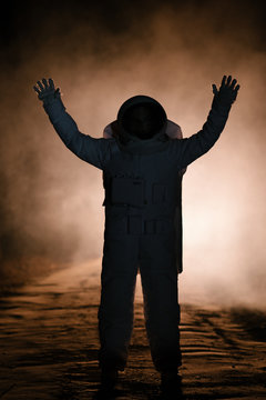 Silhouette of astronaut with hands up