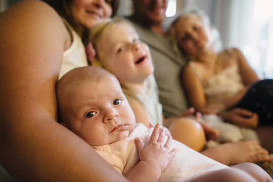 Cuddling family of five squished together on living room couch