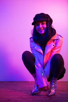 Cute rock chick woman crouching down smiling 