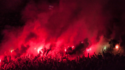 Fototapeta Football fans lit up the lights, flares and smoke bombs obraz