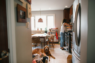 Mom cooking dinner with daughter and dog