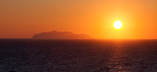 PUESTA DE SOL Y MONTAÑA EN EL HORIZONTE EN EL MAR MEDITERRÁNEO