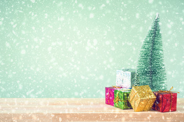 Christmas background. Christmas tree and ornaments lie on a wooden table snowy weather. Space for text. It's snowing. Merry Christmas. New Year's background. Toned image.