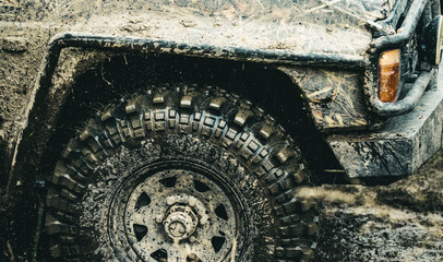 Forget about driving on smooth tarmac. Car racing offroad. Offroad car in action. Dirty car drive on high speed. SUV or offroader on mud road. Car wheels on steppe terrain splashing with dirt