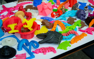 Fototapeta premium Models printed by 3d printer. Bright colorful objects printed on a 3d printer on a table close-up. Fused deposition modeling, FDM. Concept modern progressive additive technology for 3d printing.