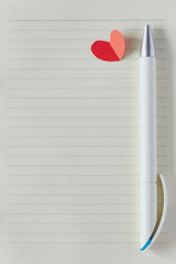 Blank page in notebook, pen and red paper heart © Olesia