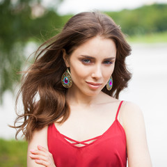 Closeup portrait of a young beautiful girl on summer background