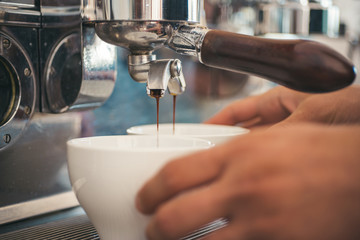 Making your favourite cup is quick. Espresso making with portafilter. Coffee being brewed in...