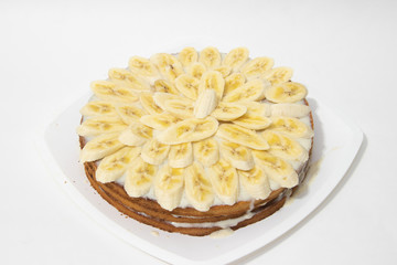 Banana cake biscuit on a white background. Sweet cake with condensed milk sauce.