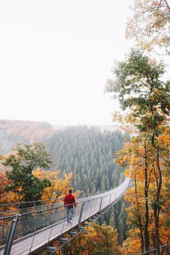Fototapeta Man walking on a long bridge in nature