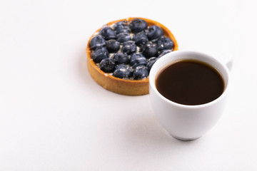 Tasty blueberry tart with vanilla cream and cup of coffee