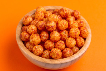 Bacon puff balls in wooden bowl on bright colorful background