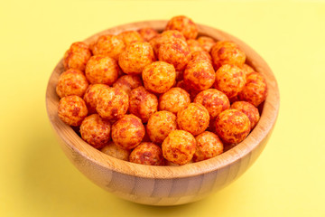 Bacon puff balls in wooden bowl on bright colorful background