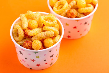 Assorted puff corn snacks in two paper cup