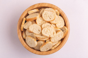 Wheat salted crackers in wooden bowl on light marble background