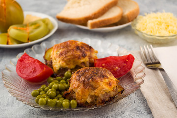 Dinner from cutlets with green peas. Marinated red and green tomatoes. Minced meat casserole with vegetables.