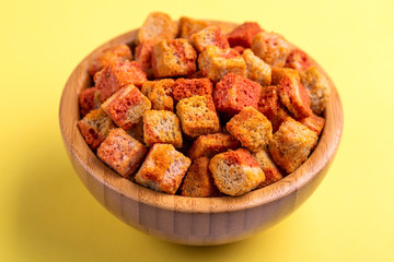 Bacon flavored crackers in wooden bowl on bright colored background