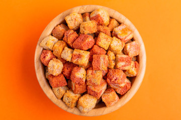 Bacon flavored crackers in wooden bowl on bright colored background