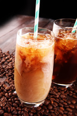 Ice coffee on a rustic table with cream being poured into it showing the texture and refreshing look of the drink
