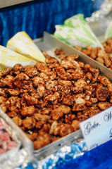 Candied or glacé walnuts browned and coated with melted sugar for a crunchy glaze, a traditional sweet snack sold at the Nürnberger Christkindlesmarkt, a Christmas market in Nürnberg, Bavaria, Germany