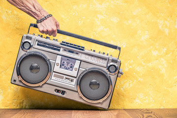 Retro outdated portable stereo boombox radio receiver with cassette recorder from circa 1980s in a...