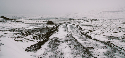 Road covered in snow one winter stormy day, very dangerous to drive due to adverse weather.