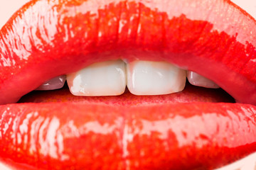 Passion. Sensual female lips. White healthy teeth. Mouth with teeth smile. Red lipstick and sexy kiss. Lips close up.