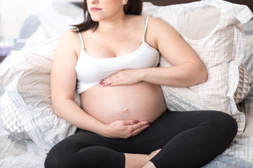 Pregnant woman with hands on her belly