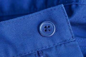 blue plastic button on the fabric of the jacket sleeve