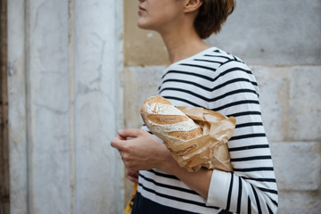 Unidentified person holding french baget bread