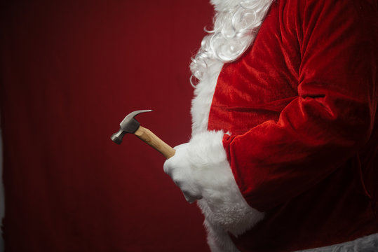 Santa Claus holding hammer in hands busy preparing decoration. Closeup view of creative ideas design, taking job assignments renovation time. Happy Christmas and New Year background.