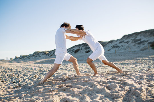 Men having fight on beach
