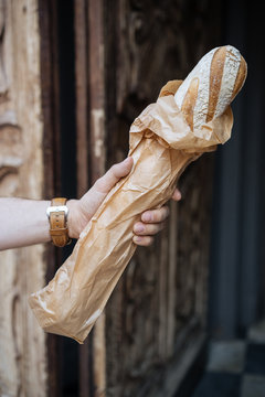 Unidentified person holding french baget bread