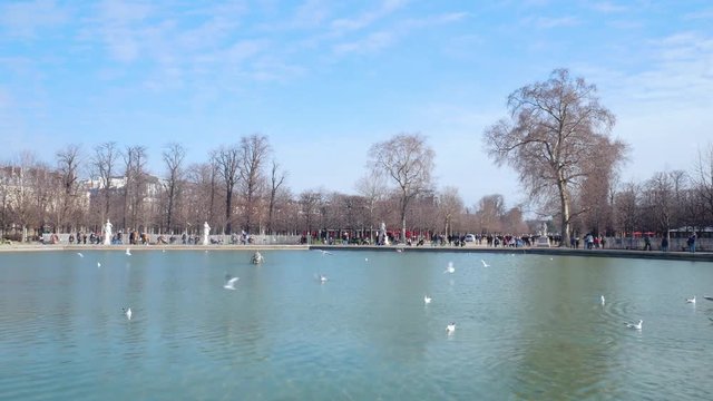 PARIS, FRANCE - People get rest around Bassin Octogonal with fountain in Garden of Tuileries near Place de la Concorde