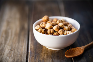 Dried cardamom pod in a bowl and wooden spoon on wooden table, herbs and spices, food ingredients